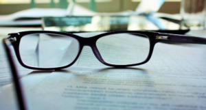 Image of Reading Glasses on White Paper With Writing